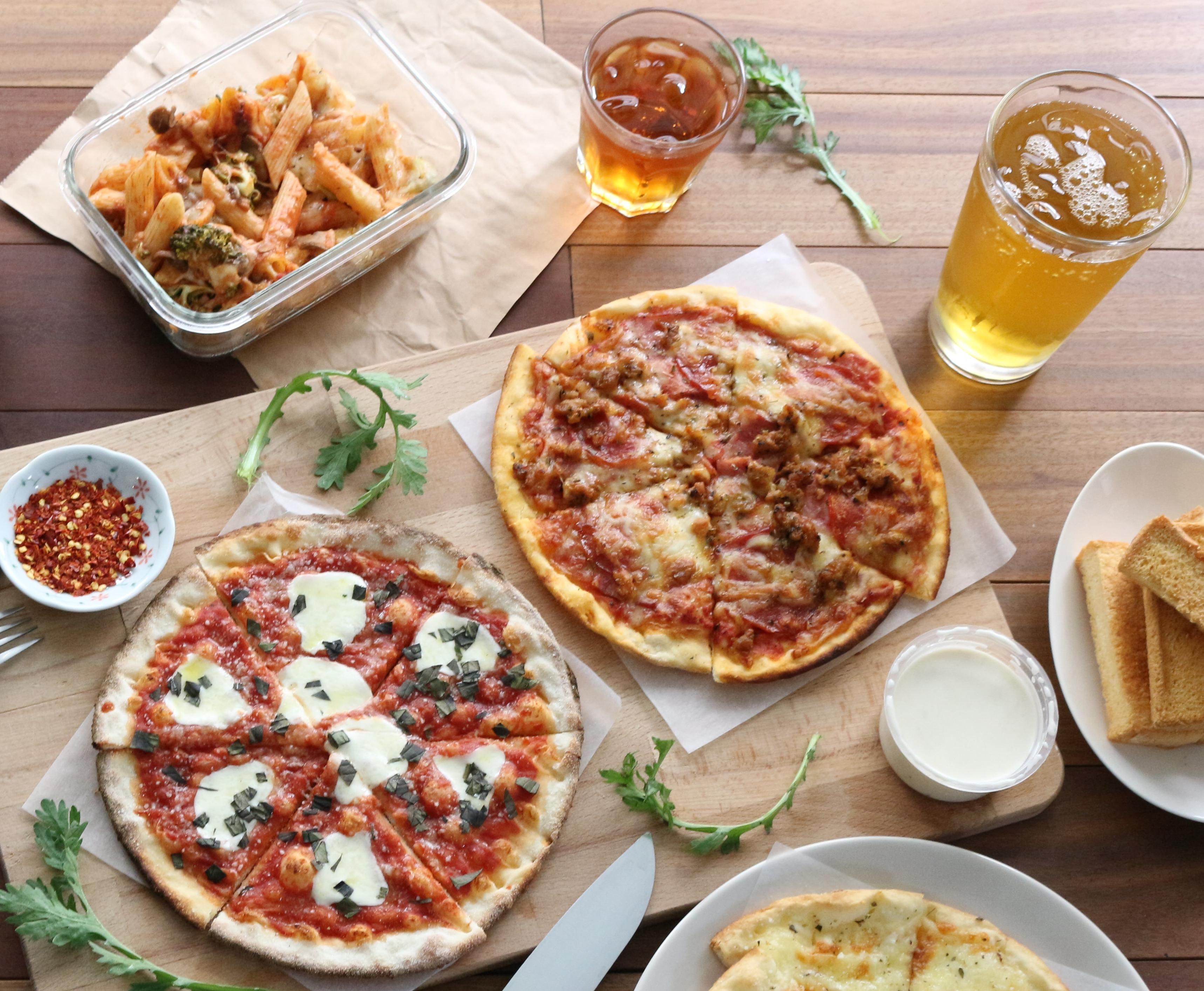 Table avec pizzas, des frites, des sodas et des sauces 