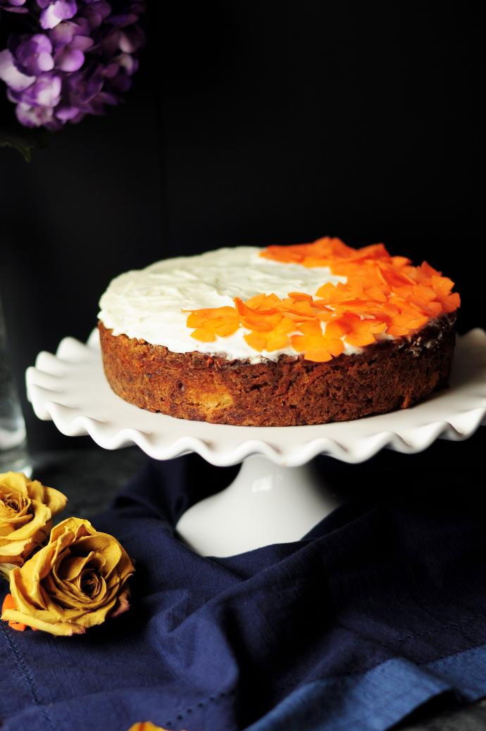 Tarte ambrée avec un nappage orangé et blanc placée sur un plat 